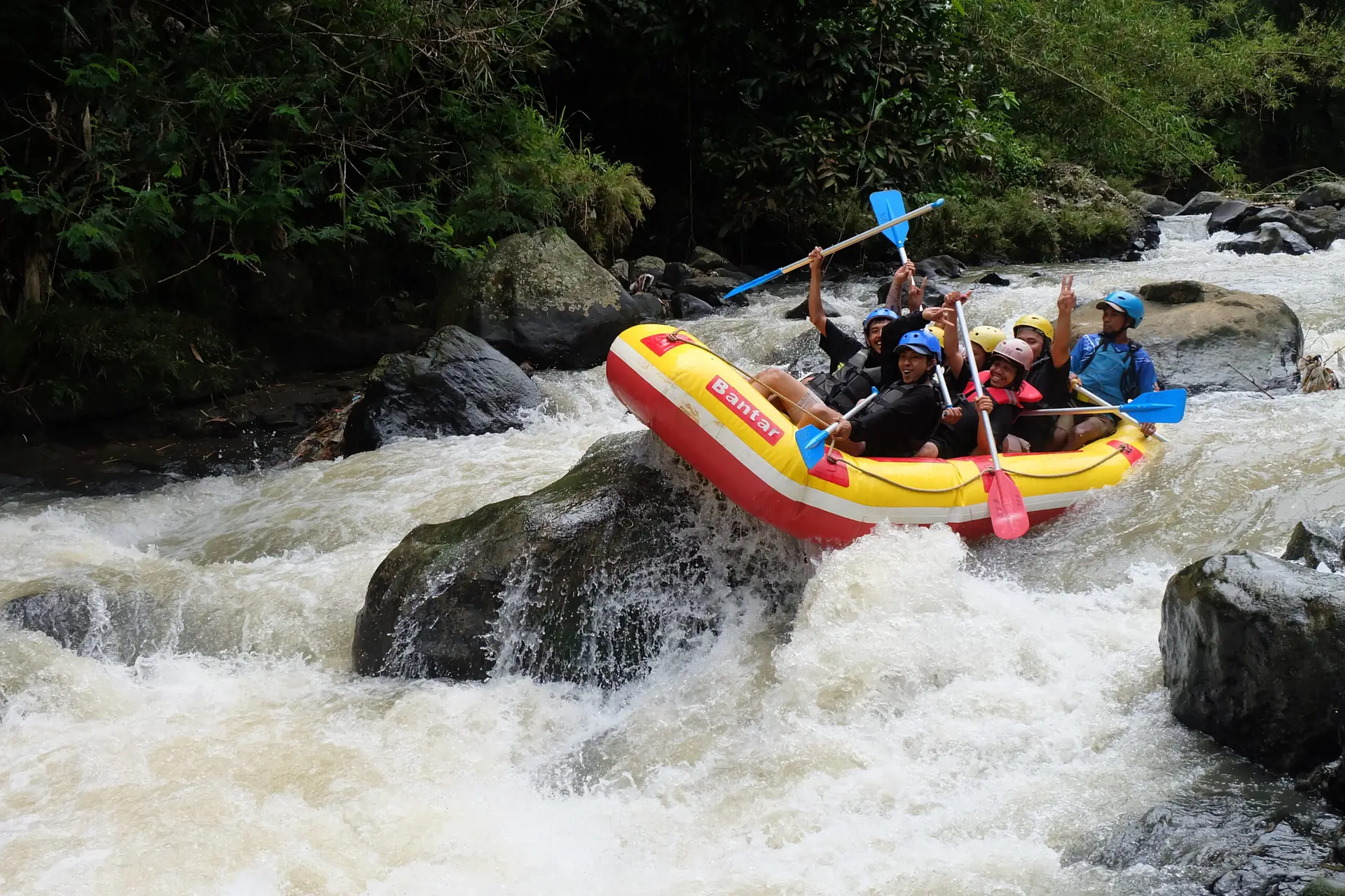 Perahu kuning melintasi jeram deras