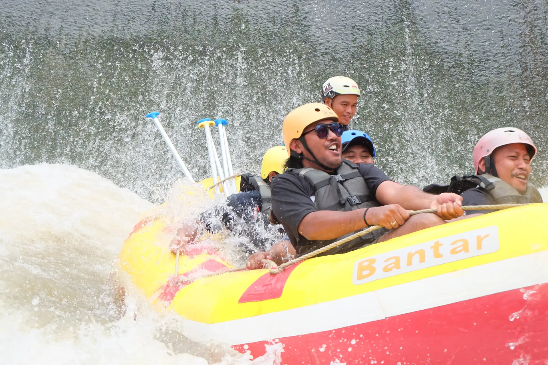 Perahu merah di jeram berbusa putih